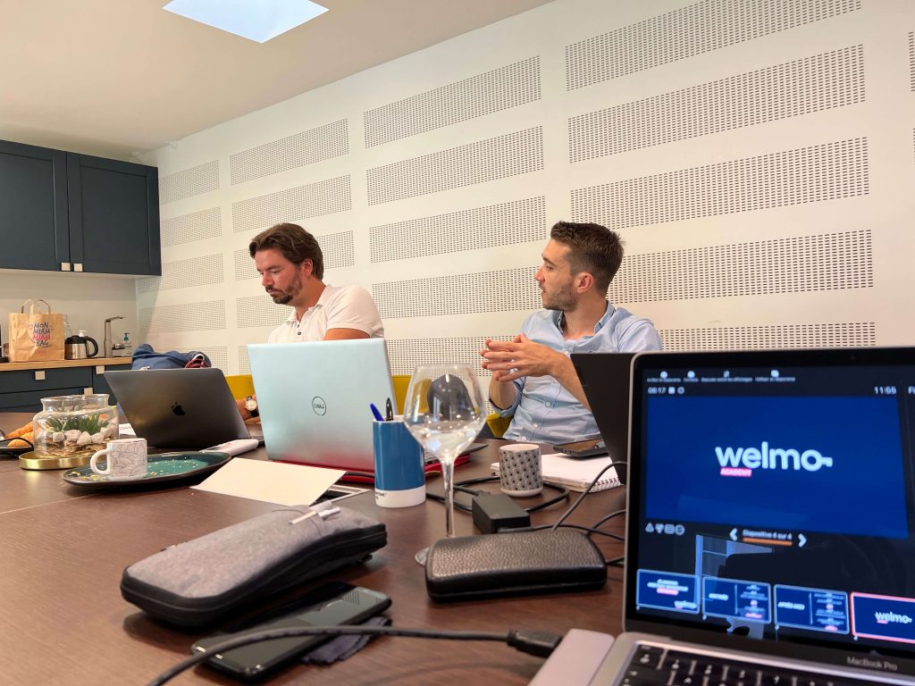 deux hommes mandataires immobiliers chez Welmo en train de travailler