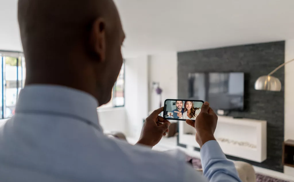 Mandataire immobilier faisant visiter un appartement en visio avec son smartphone