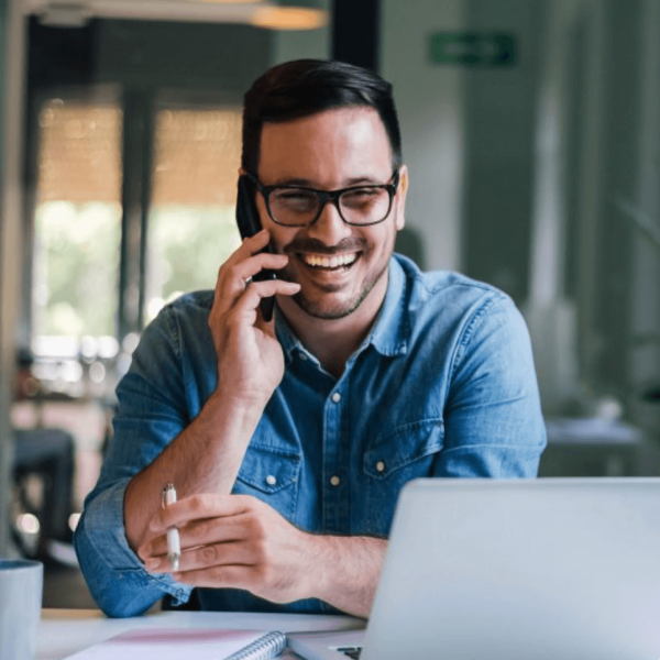 Homme au téléphone et devant son ordinateur